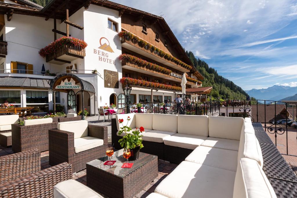 ein Hotel mit einer Terrasse mit Sofas und Tischen in der Unterkunft Berghotel in Ratschings