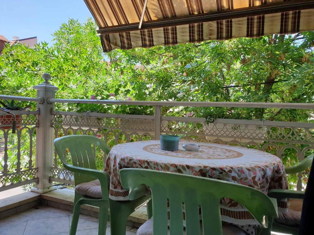 a table and chairs on a balcony with a table and a cup at City Place Apartments in Kumanovo
