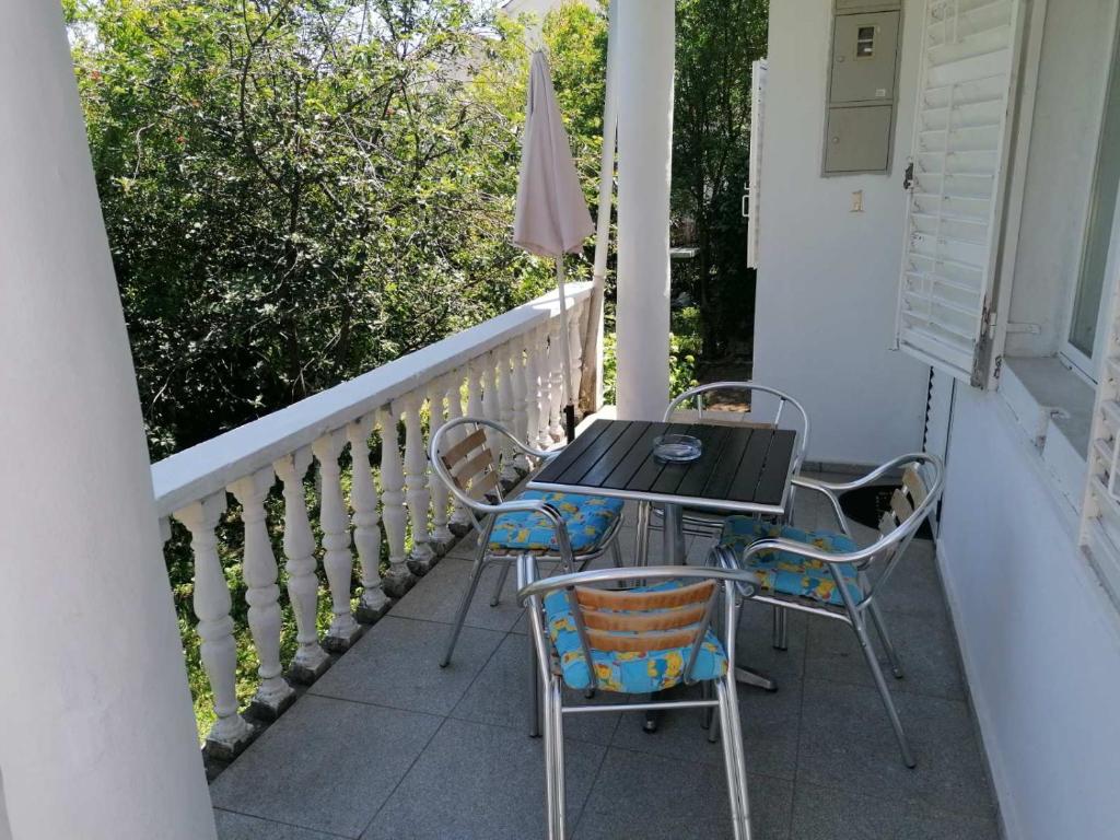 a table and chairs on the porch of a house at Apartmani Ljumović Budva in Budva
