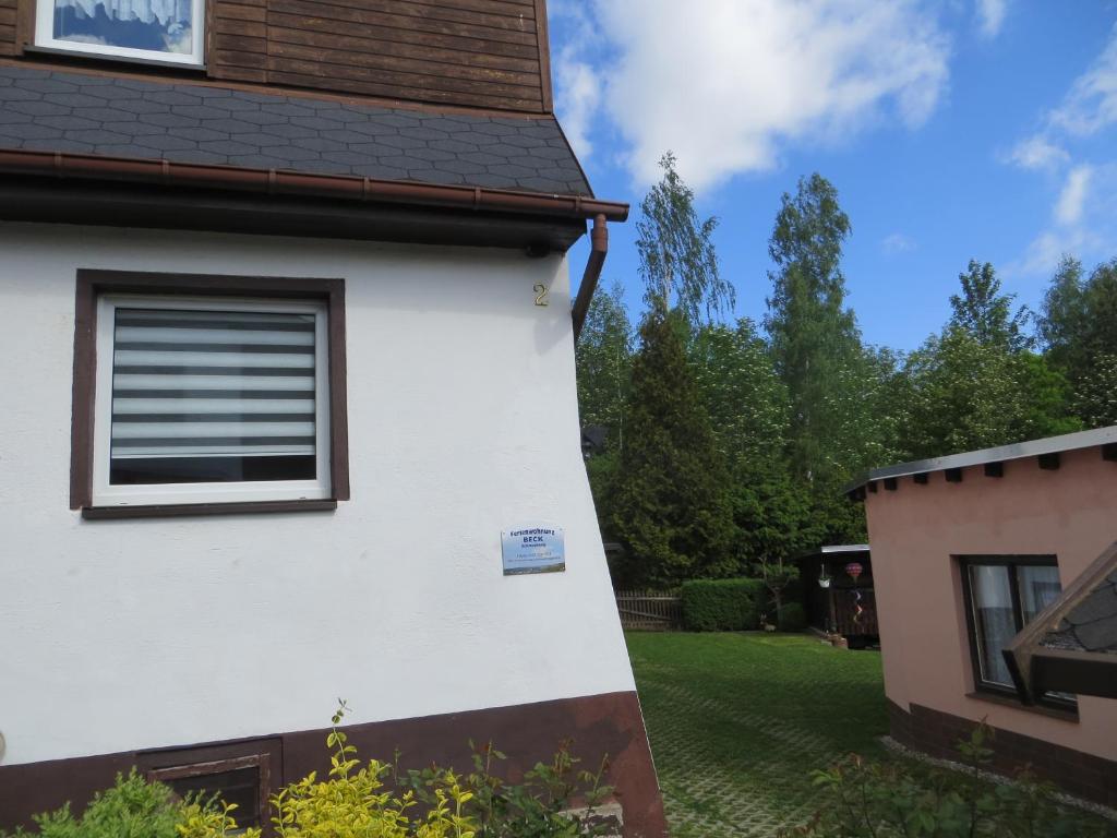 ein weißes Haus mit einem Seitenfenster in der Unterkunft Ferienwohnung Beck Schneeberg in Schneeberg