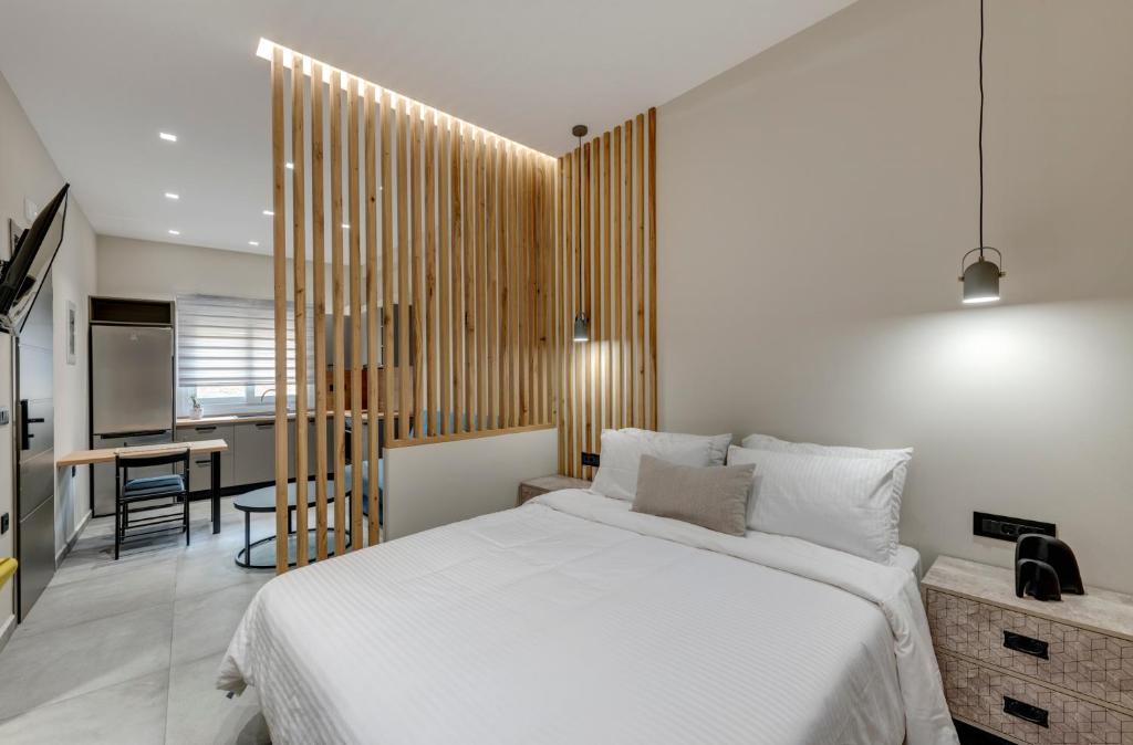 a bedroom with a white bed and a dining room at Argento urban apartments (cube) in Ermoupoli