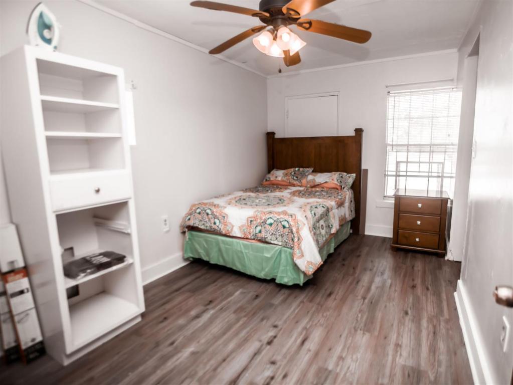 a bedroom with a bed and a ceiling fan at HISTORIC HILL APARTMENTS (Duplex) in Tuskegee