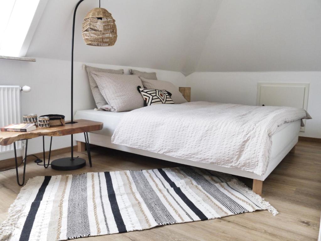 een slaapkamer met een bed, een tafel en een tapijt bij Lagunen Bude in Büsum