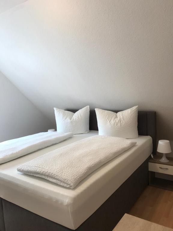 a bed with white sheets and pillows on it at DZ im Haus Maja in Holzkirchen