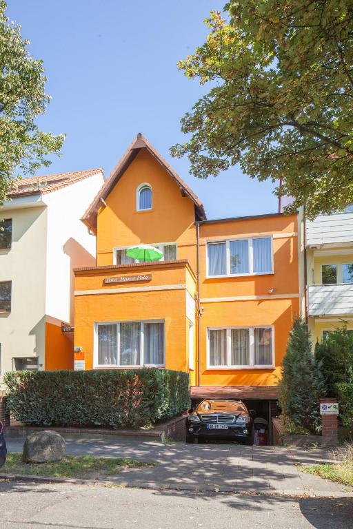 an orange building with a car parked in front of it at Hotel Marco Polo in Hamburg
