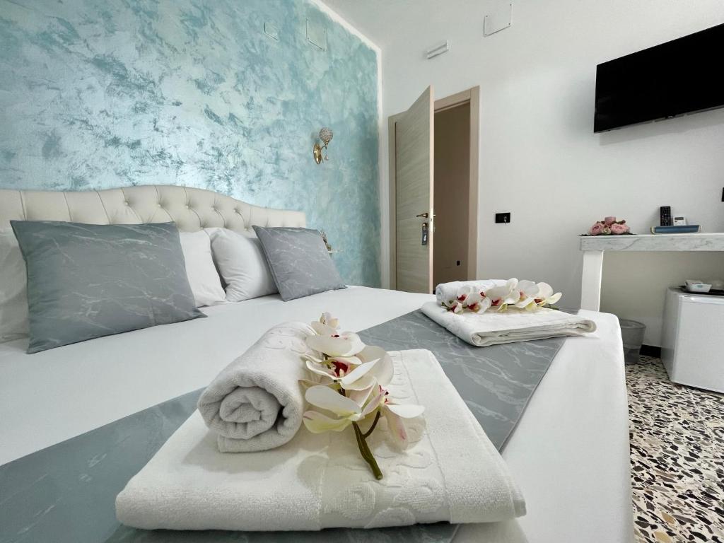 Un dormitorio con una cama con toallas y flores. en B&B Poesia, en Gallipoli