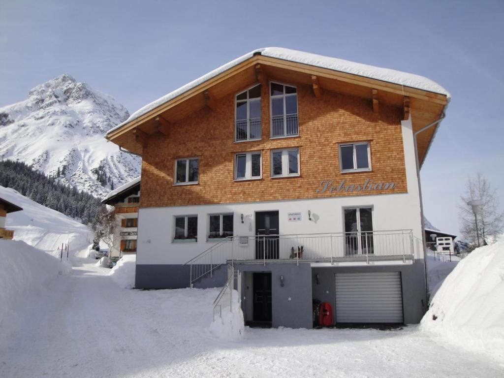 una casa en la nieve frente a una montaña en Haus Sebastian, en Lech am Arlberg