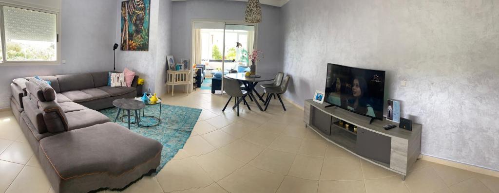 a living room with a couch and a flat screen tv at Marina Golf Asilah in Asilah