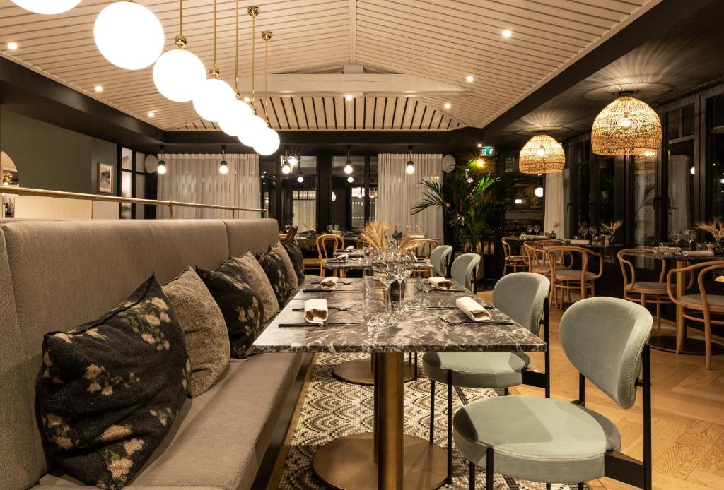 a dining room with a couch and a table and chairs at Le Celtique & Spa in Carnac