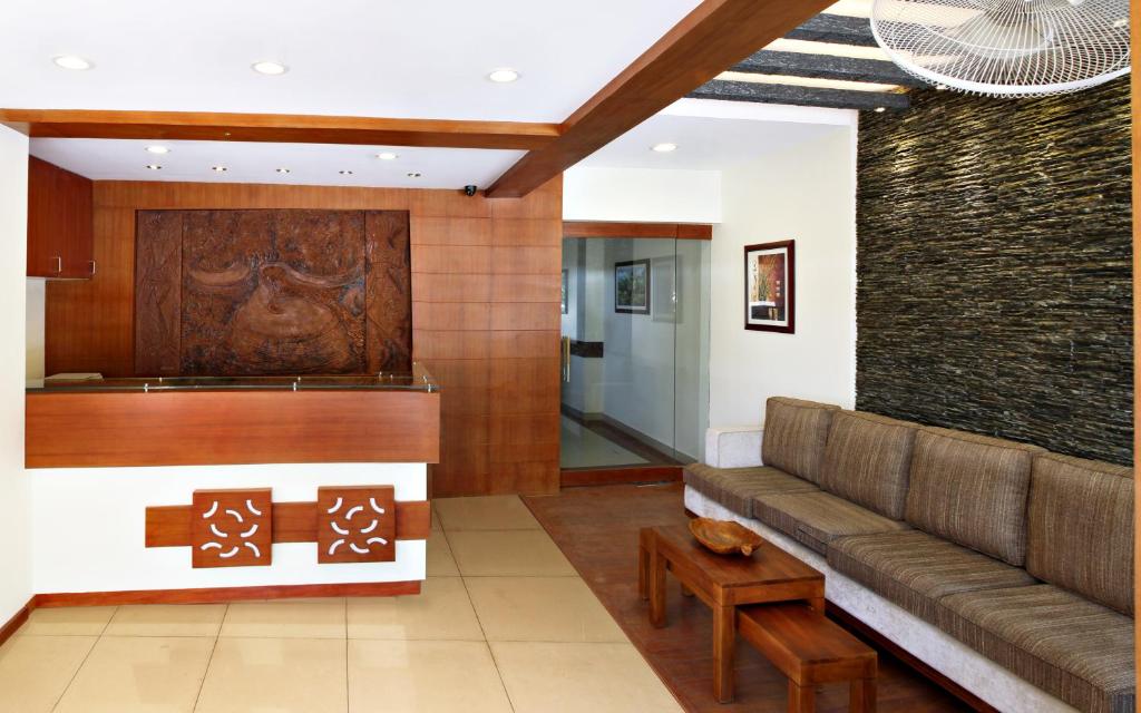 - un salon avec un canapé et un mur dans l'établissement Century Grand Hotel, à Mananthavady