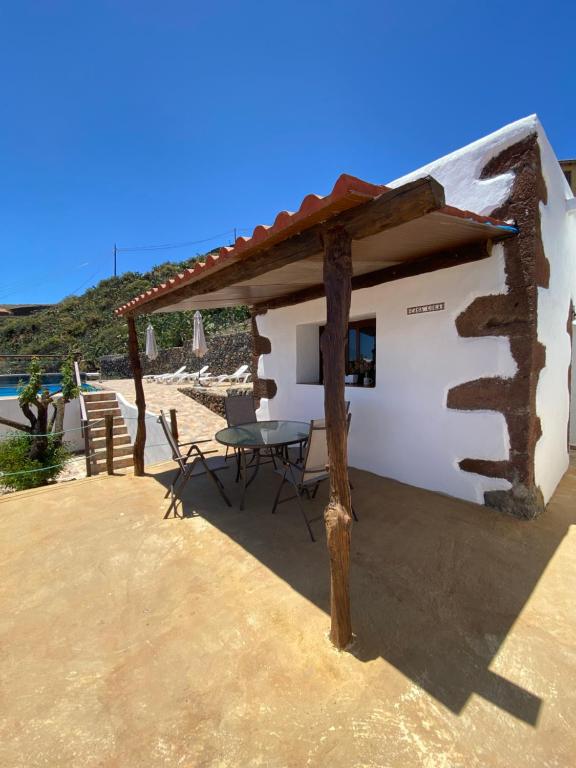 een huis op het strand met een tafel en stoelen bij Vivienda Vacacional Casa Lola in Taibique