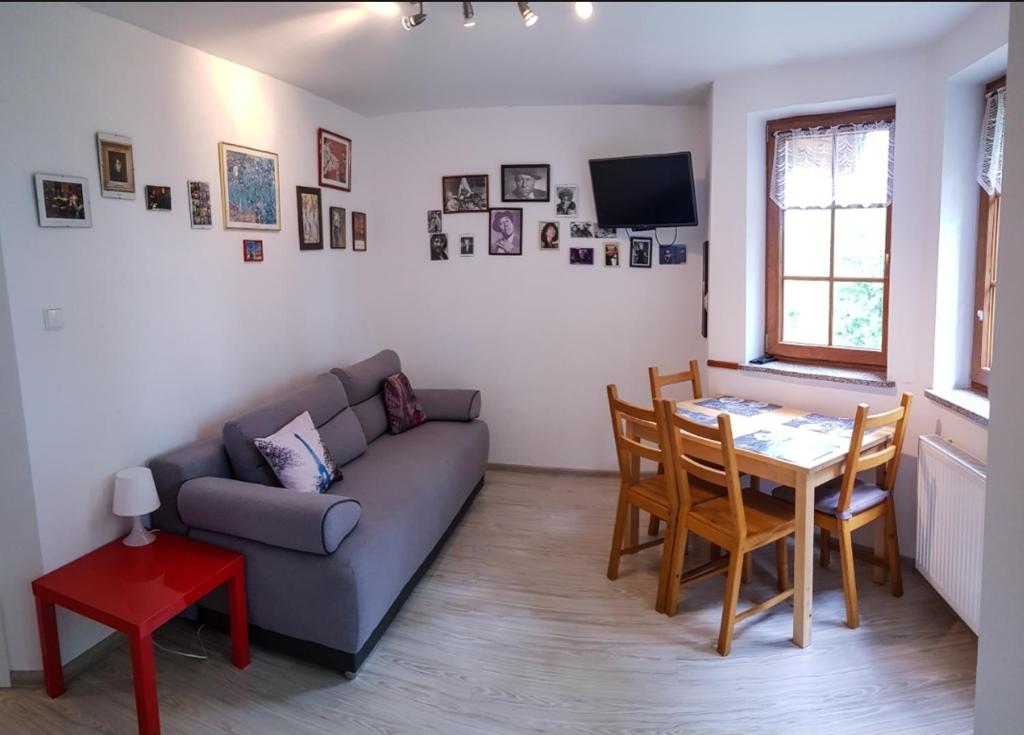 a living room with a couch and a table at Apartament Paryski in Karpacz