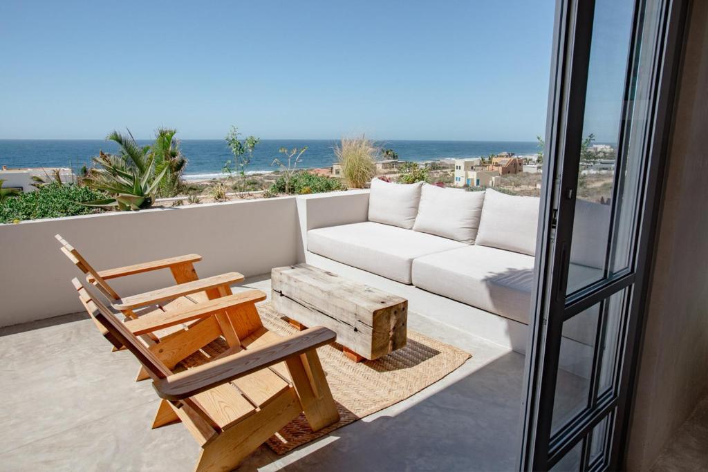 sala de estar con sofá y silla en el balcón en Topia Retreat - Surf Suite Sur, en El Pescadero