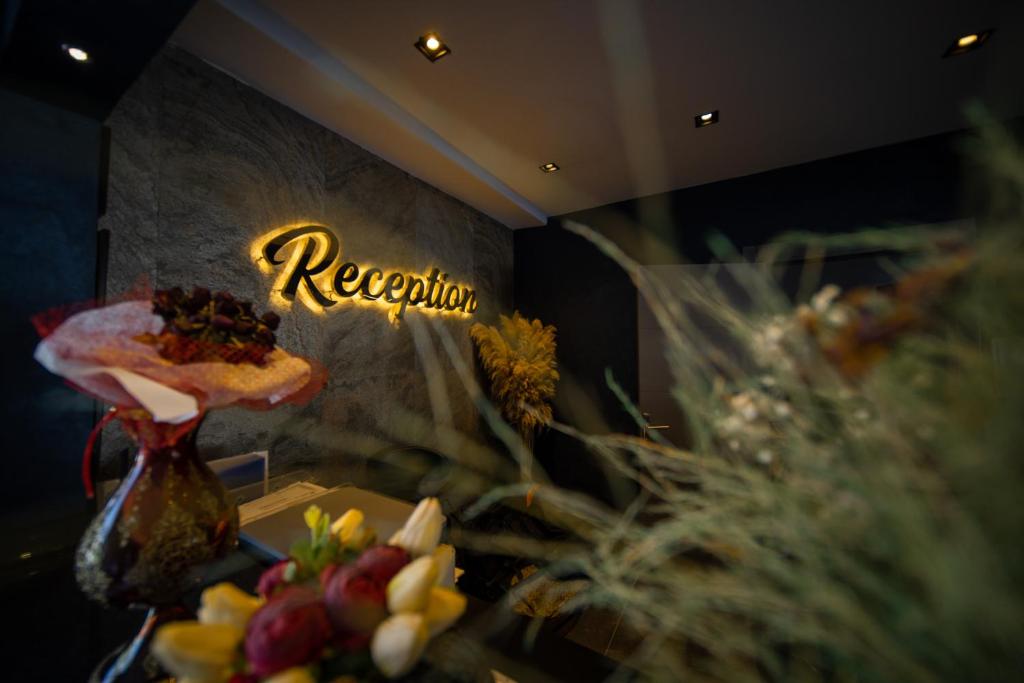 a room with flowers and a sign that says reception at Sea Palm Otel Yalıkavak in Yalıkavak