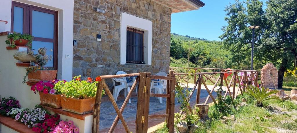 a stone house with a patio and flowers on the side at La casa in campagna in Perdifumo