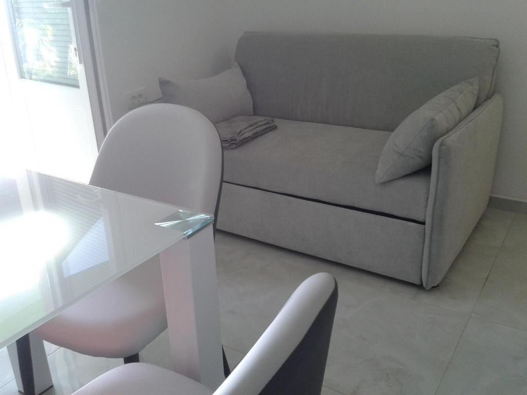 ein Wohnzimmer mit einem Sofa und einem Glastisch in der Unterkunft SEA VIEW in Zadar