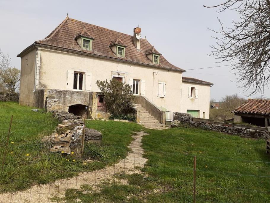 ein großes weißes Haus auf einem Hügel mit einem Grasfeld in der Unterkunft Maison dans un petit Mas en pleine campagne in Saint-Jean-de Laurs