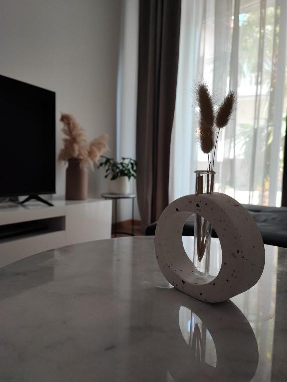 un vase avec des plumes assise sur une table dans l'établissement Apartment Eda, à Pula
