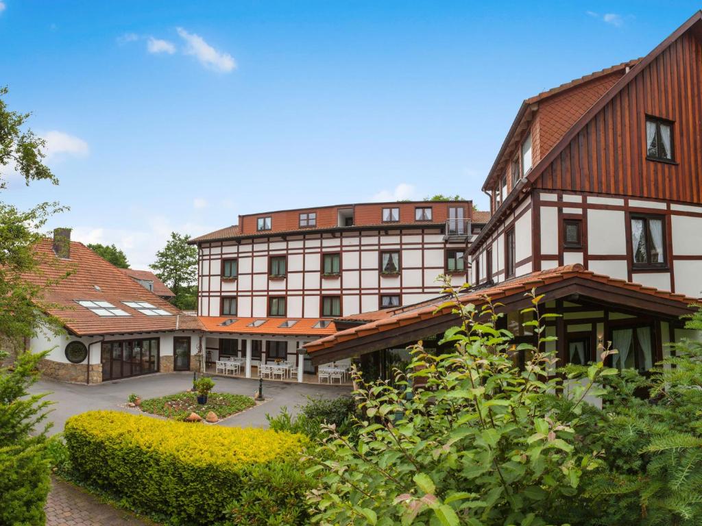 um grande edifício com telhados vermelhos e um pátio em Landhotel Der Schwallenhof em Bad Driburg