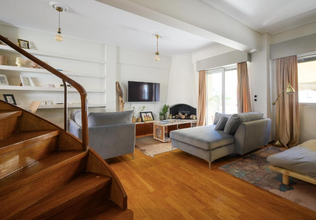 een woonkamer met een trap en een bank bij Relaxed Art Deco Maisonette Pagrati in Athene