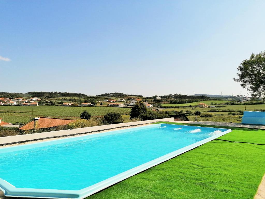 een groot zwembad in een tuin met groen gras bij Quinta Sobral Prestige - Little Rustic in Sobral de Monte Agraço