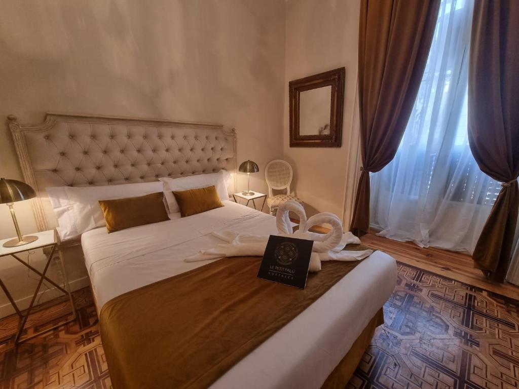 Un dormitorio con una cama con un libro. en Le Petit Palü- Flora, en Madrid