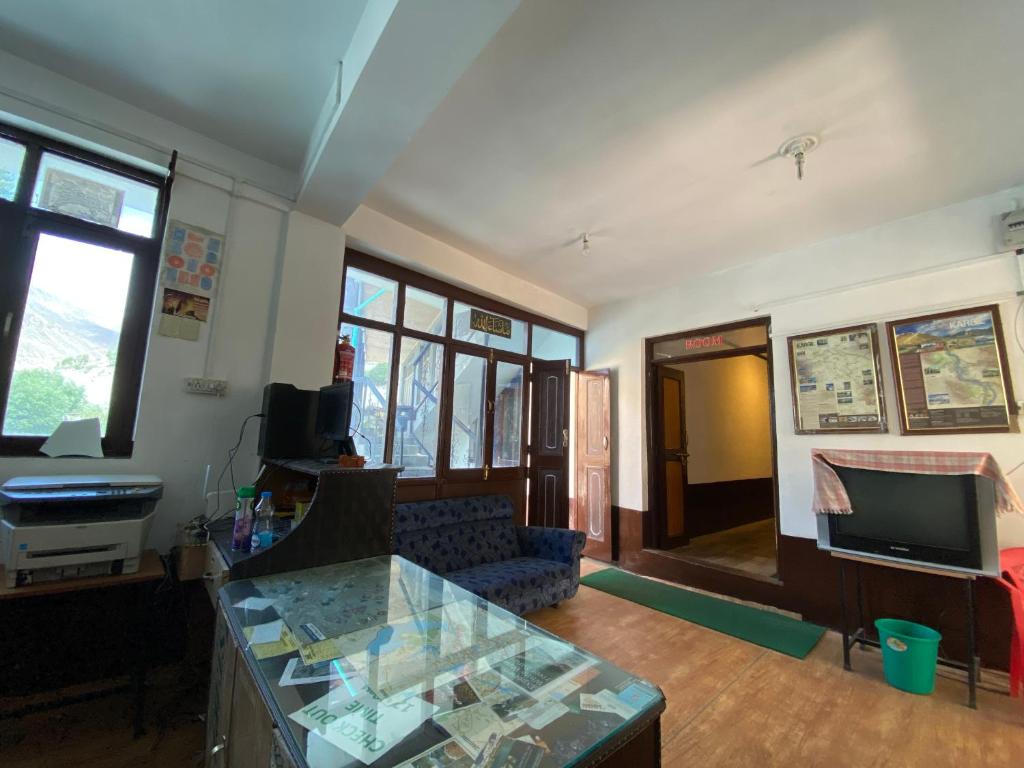 a living room with a couch and a glass table at Ashiyana Hotel in Kargil