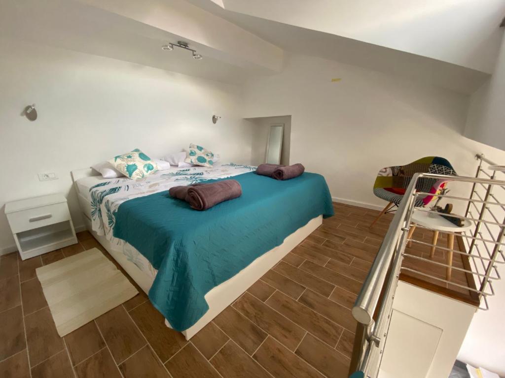una camera con un letto e una coperta blu di Apartmani Begic 1 i 2 a Barbat na Rabu
