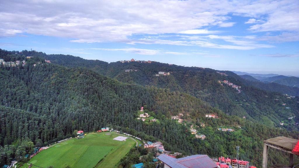 an aerial view of a green field in the mountains at Prairie Lodge in Shimla