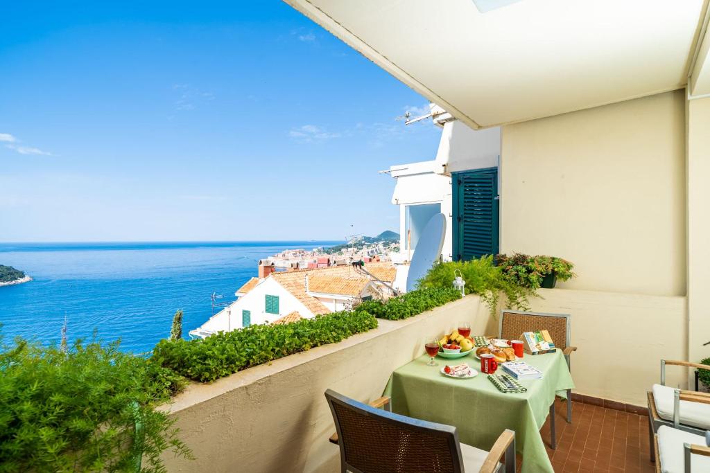 a table on a balcony with a view of the ocean at Apartment Bakus in Dubrovnik