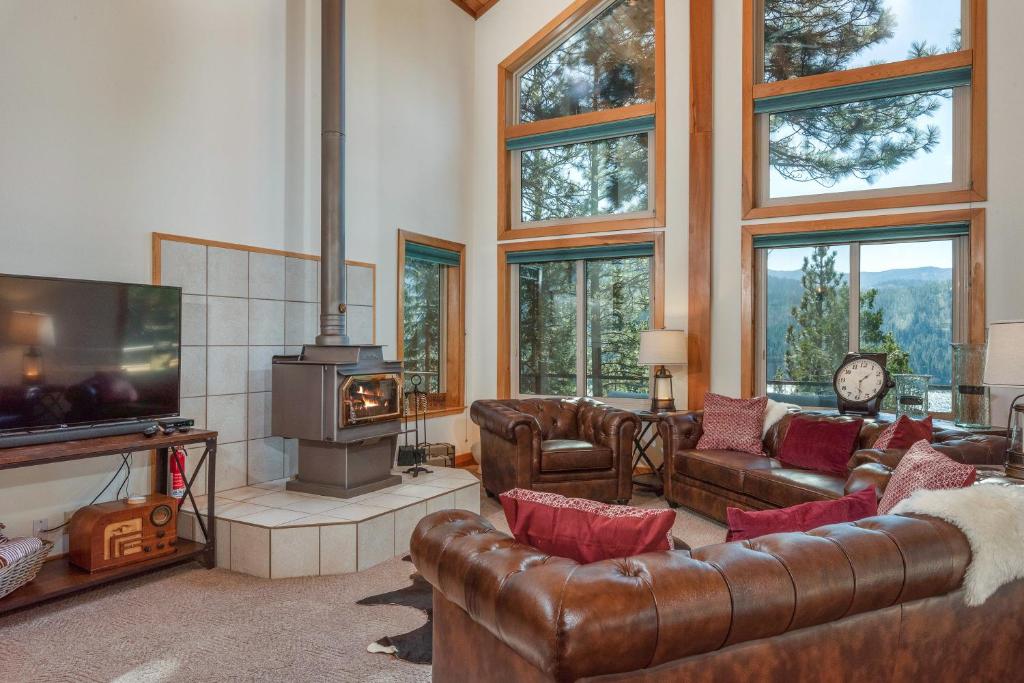 a living room with leather furniture and a tv and a fireplace at Heaven by the Lake in Truckee