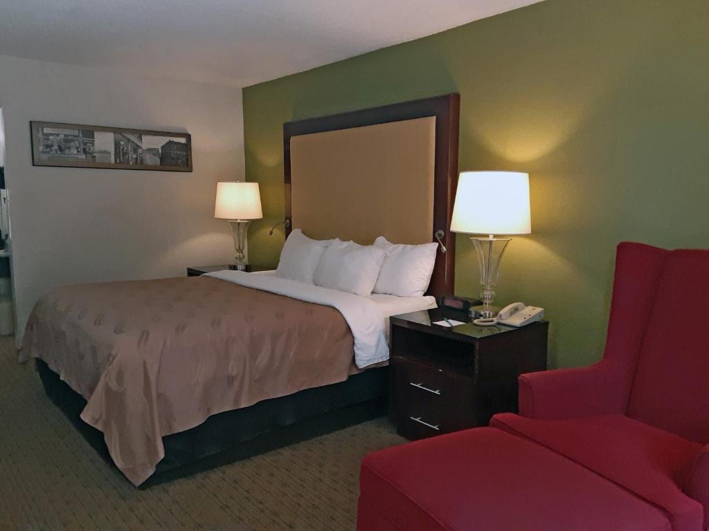 Habitación de hotel con cama y silla roja en Quality Inn en Morganton