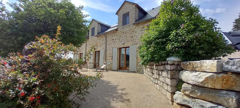 an external view of a stone house with a stone wall at Studio nature a la ferme in La Canourgue