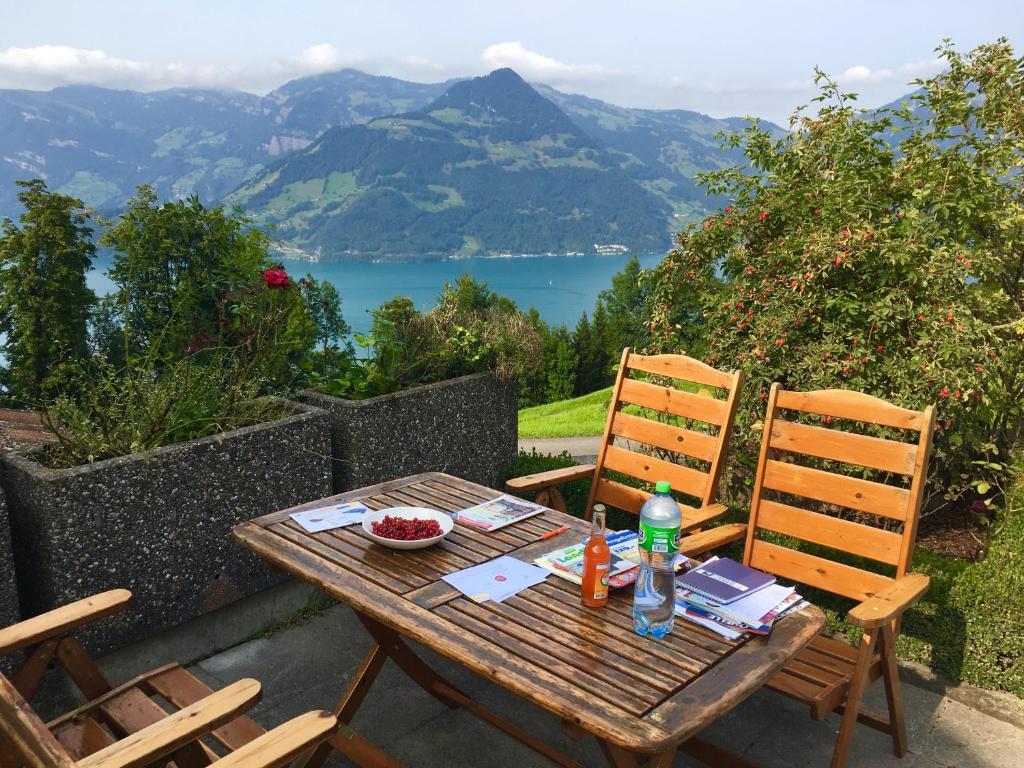 a wooden table and chairs with a view of a lake at Mountain peace in the heart of Switzerland in Emmetten