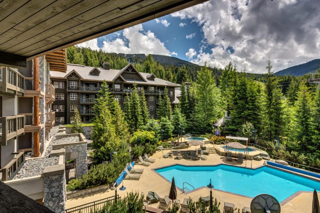 an aerial view of a resort with a pool and mountains at Blackcomb Springs Suites by CLIQUE in Whistler