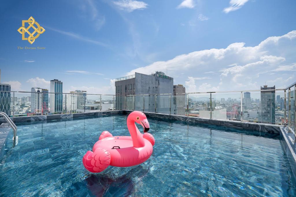 ein rosa Schwan schwimmt in einem Pool auf einem Gebäude in der Unterkunft The Dream Suite in Đà Nẵng
