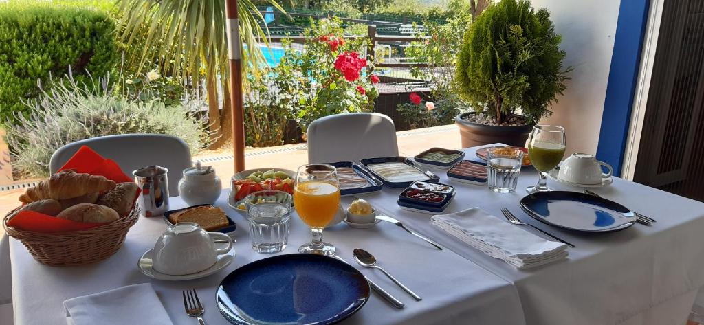 ApraHouseLoule Guesthouse في لولي: طاولة عليها قماش الطاولة البيضاء مع الطعام