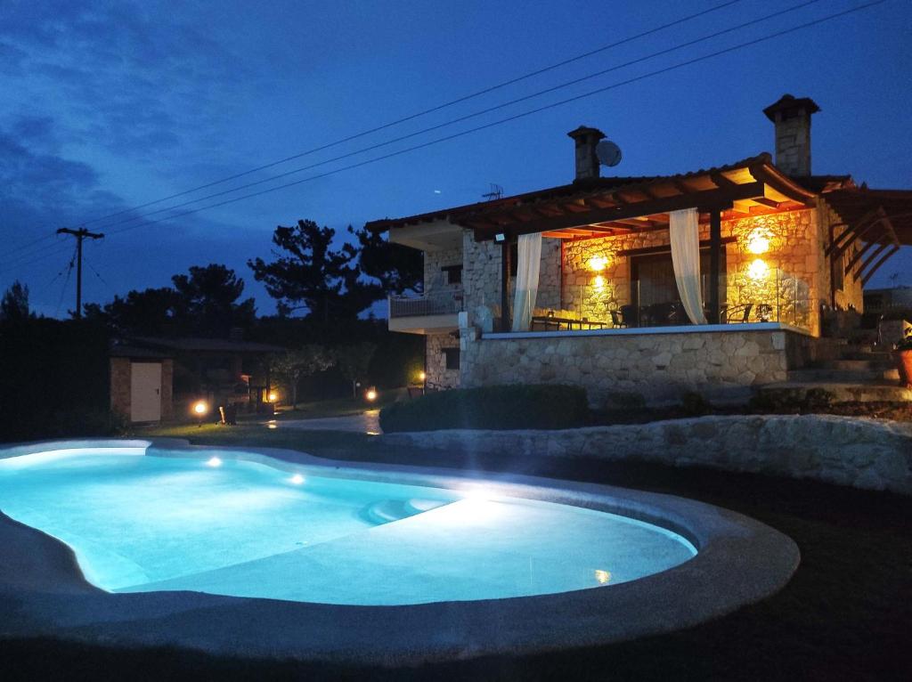 a swimming pool in front of a house at night at Villa Traditional Estate Heated Pool & Garden, 5 bedrooms in Metókhion Patriotikón