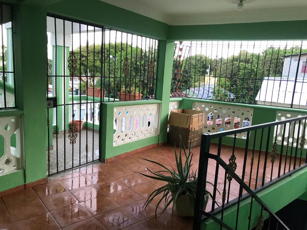 un balcón con paredes verdes y una puerta con una planta en Villa Valencia - 3 Habitaciones - 1ª Planta, en Los Patos