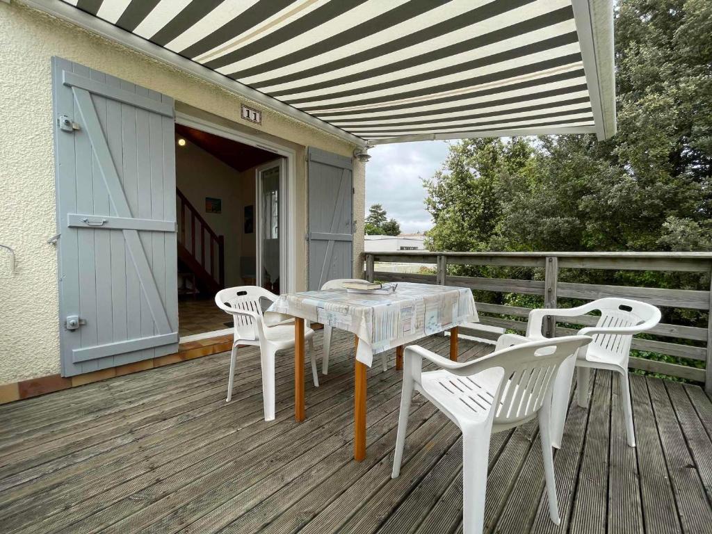 un patio avec une table et des chaises sur une terrasse dans l'établissement Appartement Cosy avec Terrasse Intime, à 500m de la Plage de Nauzan - FR-1-550-37, à Vaux-sur-Mer