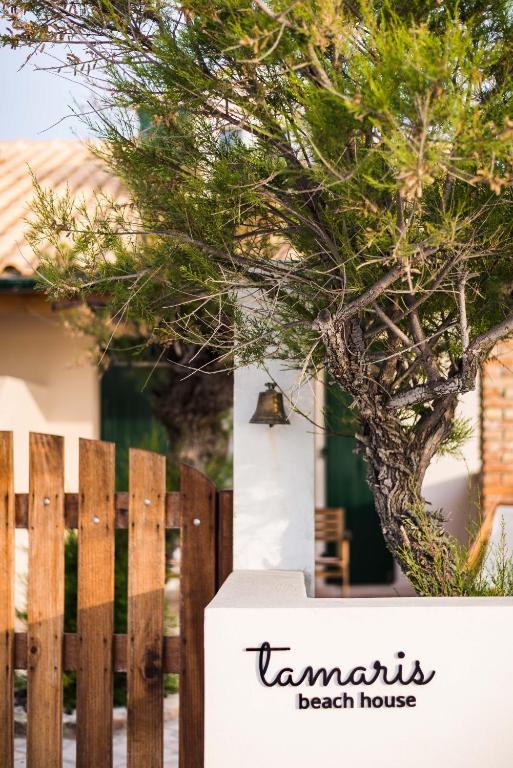 a sign that reads tamaris beach house next to a fence at Tamaris Beach House in Acharavi
