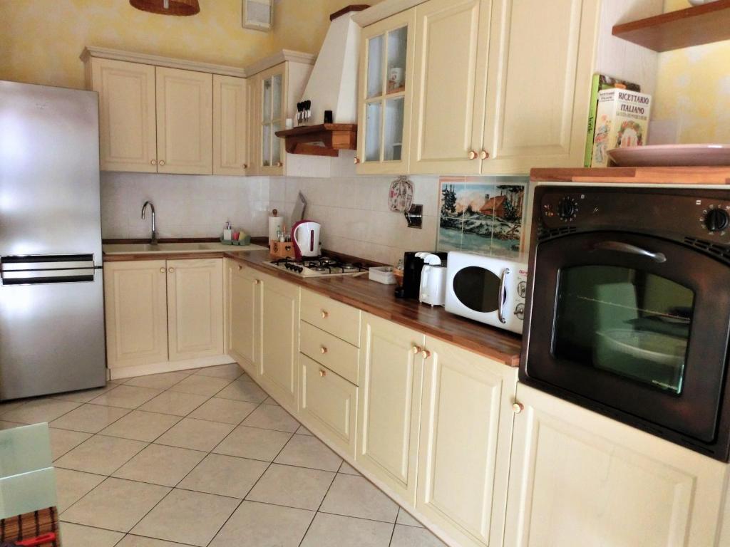 a kitchen with white cabinets and a microwave at Casa di Giada appartamento luminoso a due passi dalla tramvia per Firenze in Scandicci