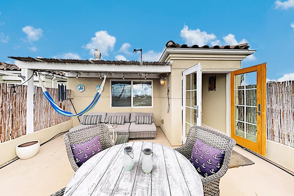 a patio with a wooden table and chairs at Westwood House in Oceanside