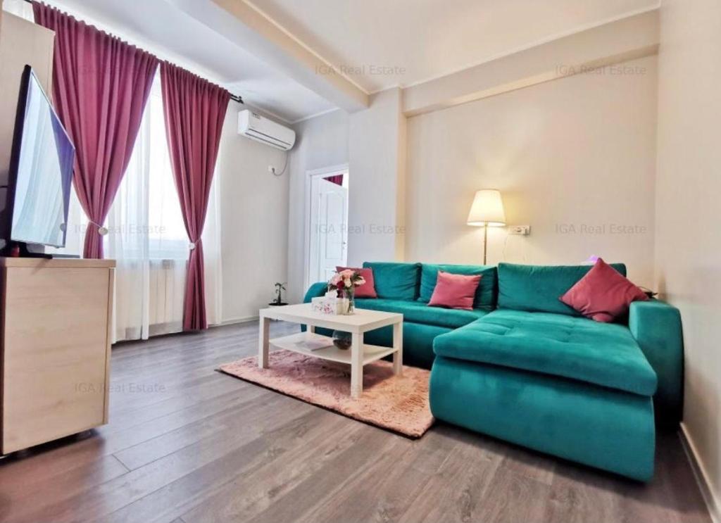 - un salon avec un canapé vert et une table dans l'établissement Sea View Apartament, à Mamaia Nord – Năvodari