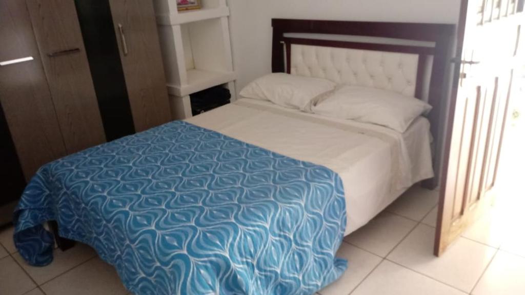 a bedroom with a bed with a blue and white comforter at CASA De MÃE - CAMPINA GRANDE in Campina Grande