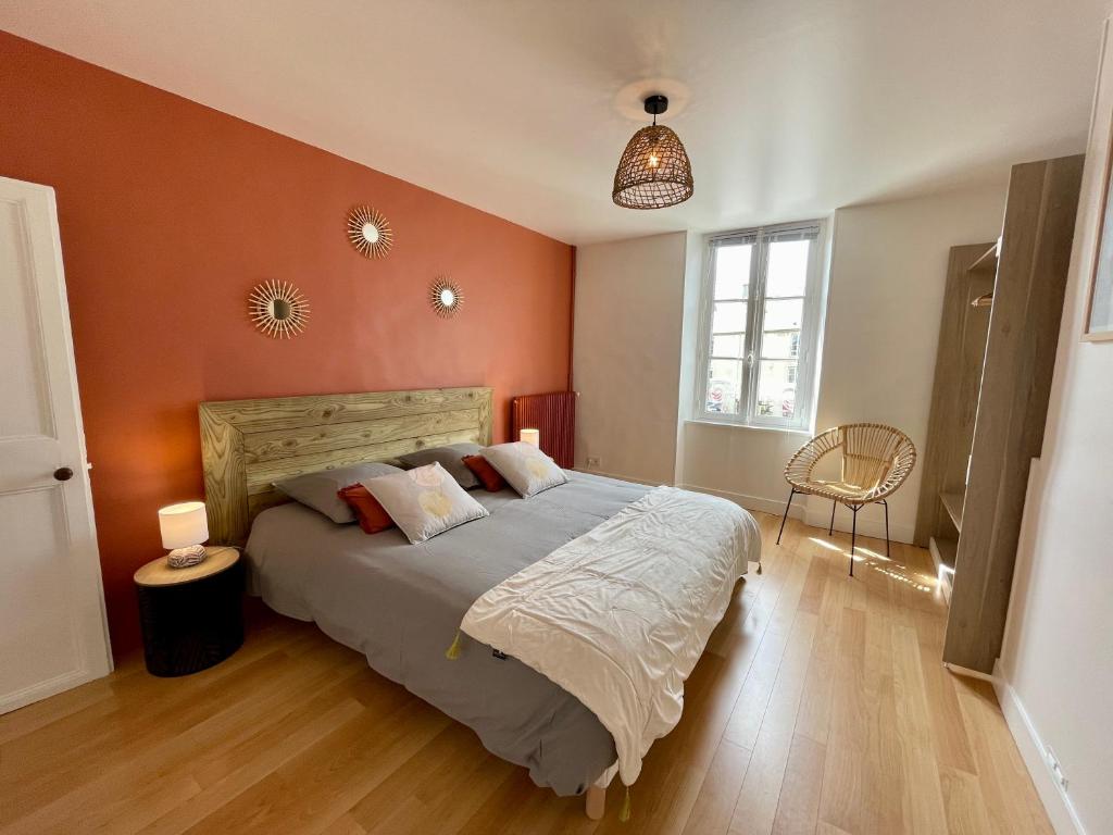 ein Schlafzimmer mit einem großen Bett mit orangefarbenen Wänden in der Unterkunft Le Cosy in Bayeux