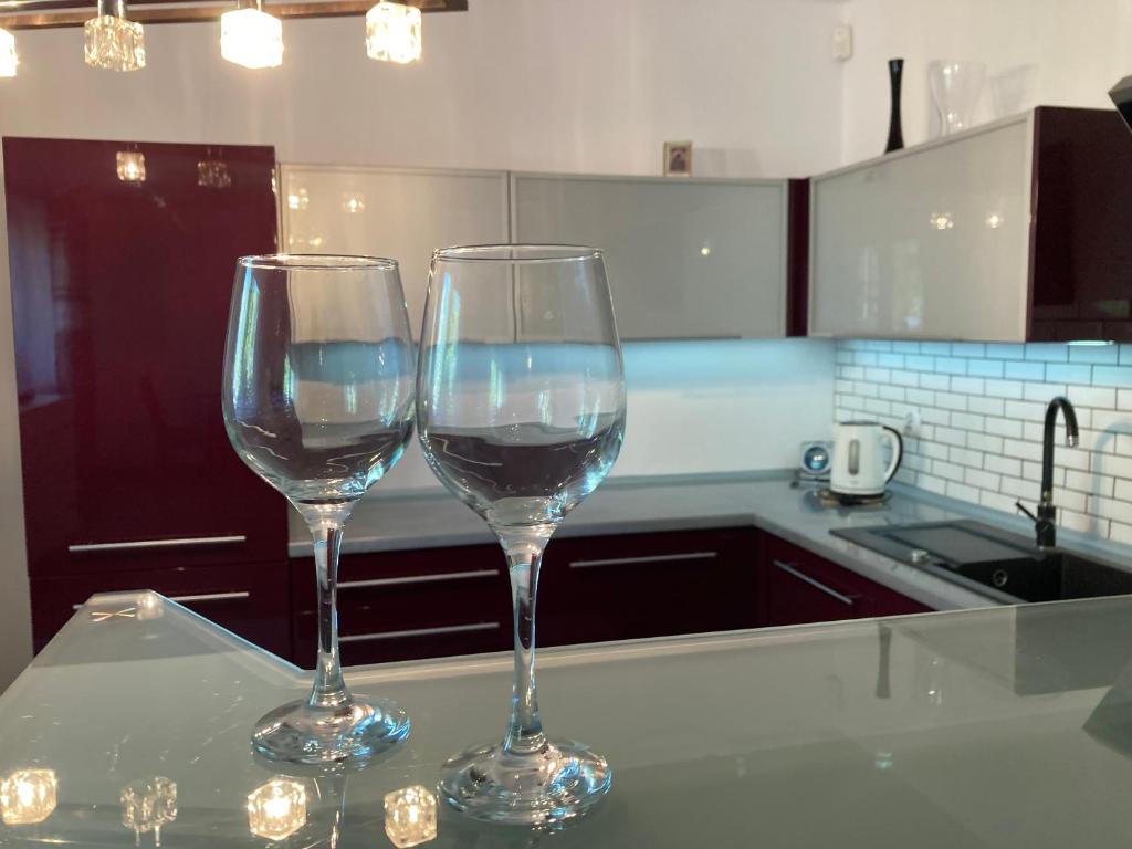 two wine glasses sitting on a counter in a kitchen at Dom Chotomów in Chotomów