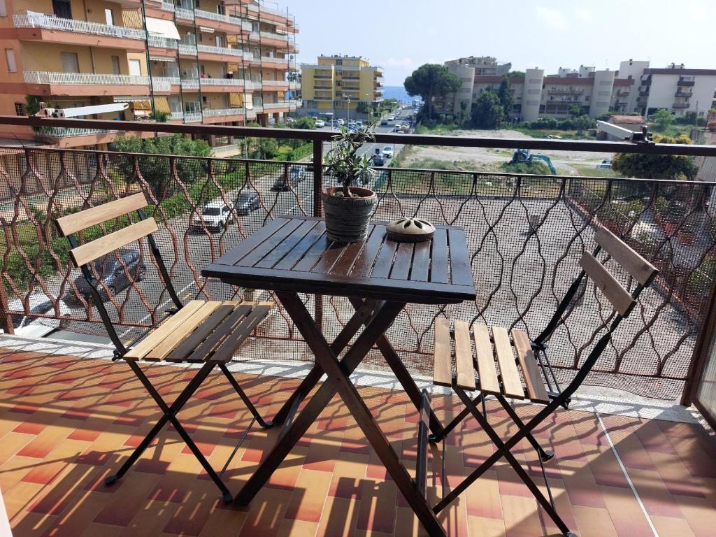 uma mesa preta e duas cadeiras numa varanda em Casa Laura em Ventimiglia