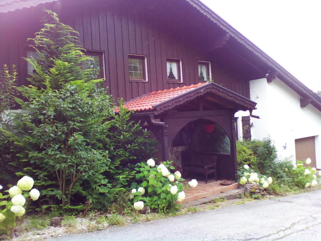 een huis met een veranda met een stoel op de veranda bij Haus Alpenblick in Zenting