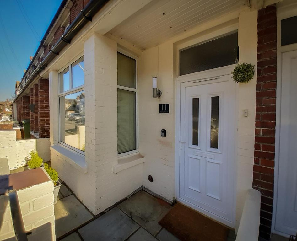 una puerta blanca en el lateral de un edificio en Welcoming 4 Bed Holiday Home in Eastbourne en Eastbourne